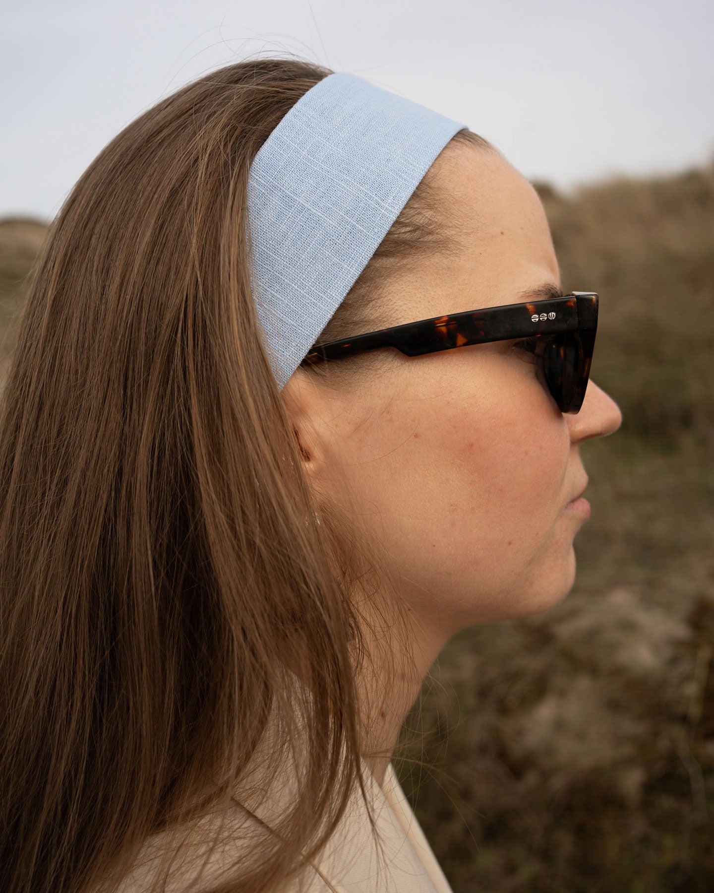 Side shot model wearing bandega headband linen ivory blue